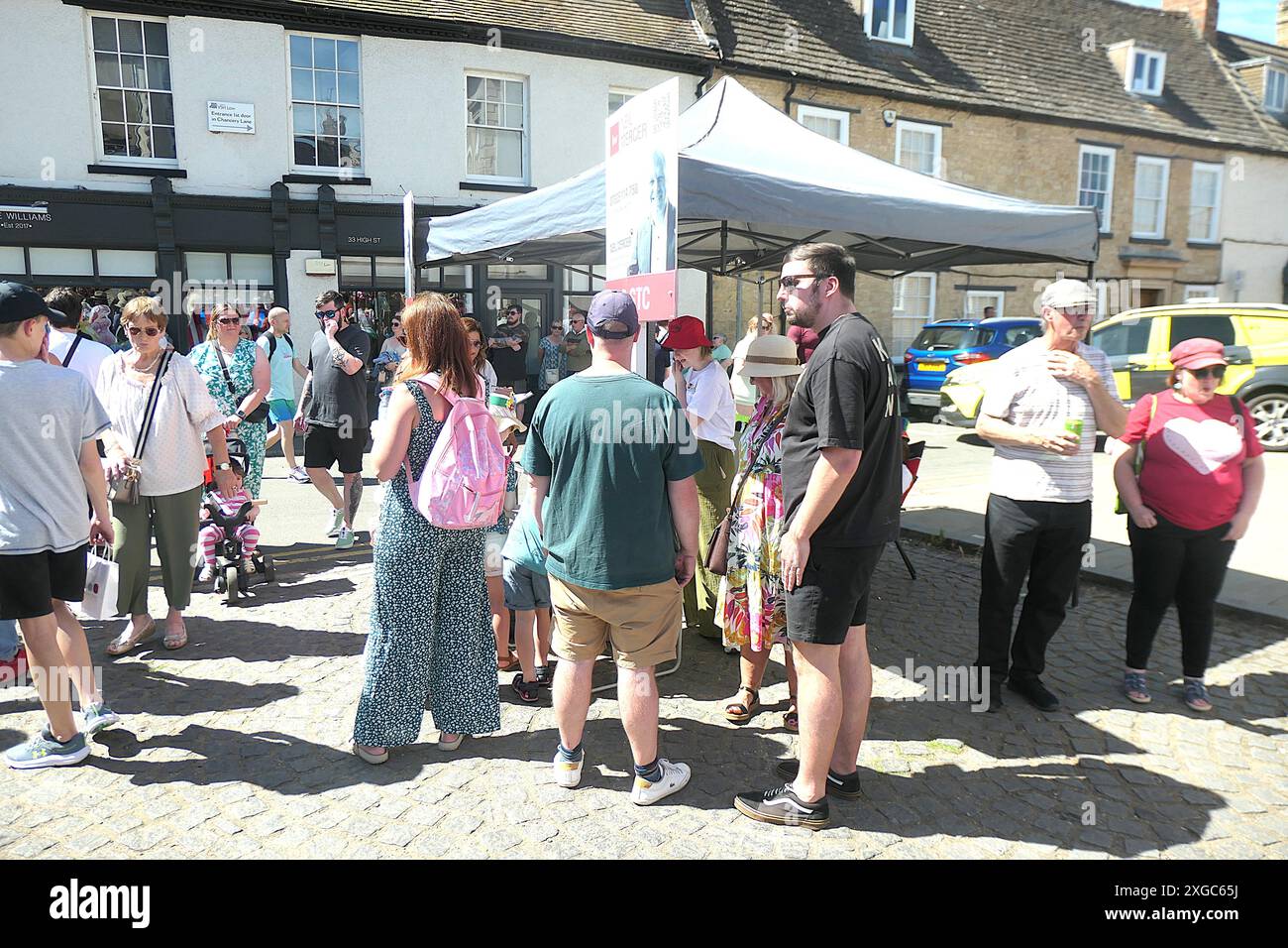 Thrapston charter Fair Rock Choir cantare in strada canzoni felici tempo estivo luogo persone che guardano infermiere bancarelle ambulanza bancarelle tempo caldo Foto Stock