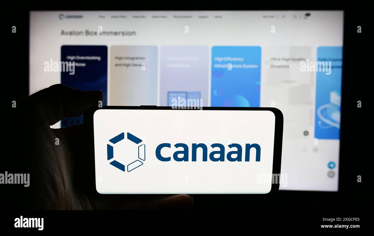 Persona che detiene un cellulare con il logo della società cinese di hardware informatico Canaan Inc. Di fronte alla pagina web aziendale. Mettere a fuoco il display del telefono. Foto Stock