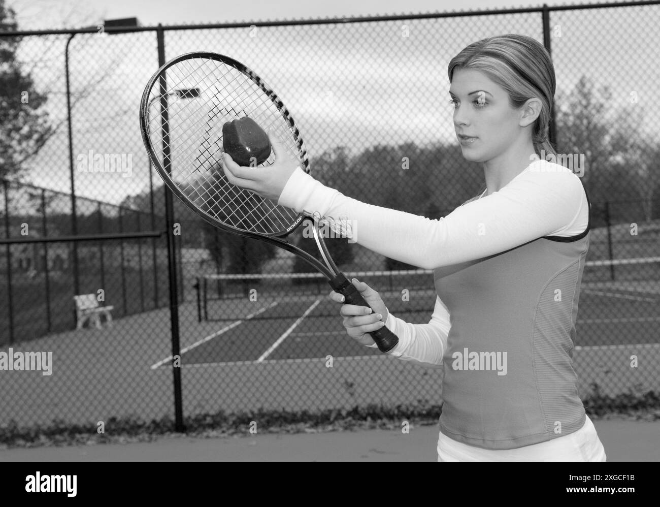 Adolescente caucasica dai 15 ai 17 anni che serve una mela con una racchetta da tennis. STATI UNITI Foto Stock