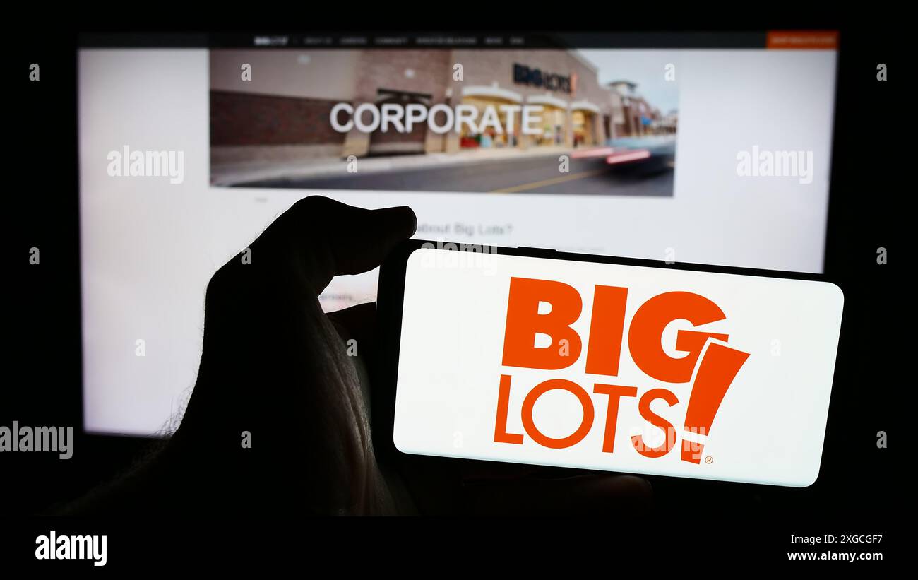 Persona che possiede uno smartphone con il logo della società di vendita al dettaglio statunitense Big Lots Stores Inc. Davanti al sito Web. Mettere a fuoco il display del telefono. Foto Stock