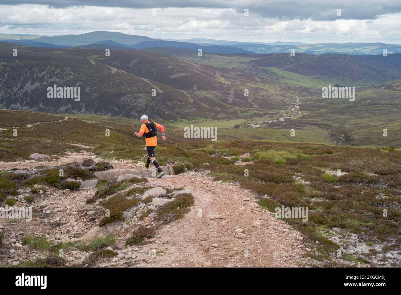 Hill Runner vicino alla cima del Monte Keen con glen tanar alle spalle. Parco nazionale di Cairngorms in scozia Foto Stock