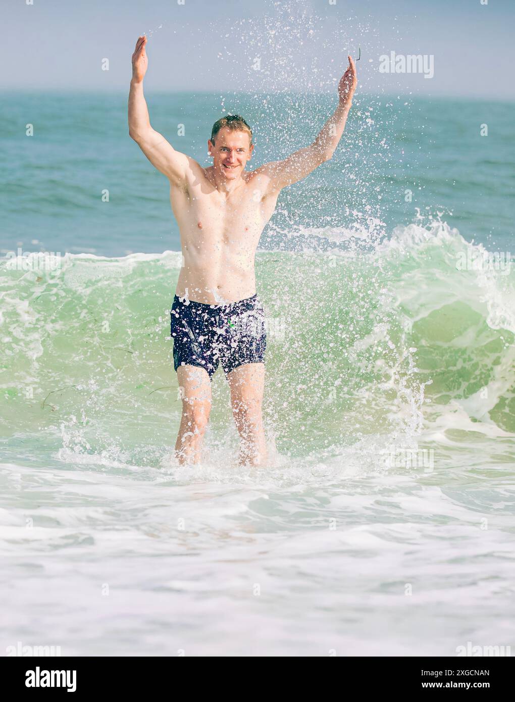 Bell'atletico sulle onde dell'oceano a Long Beach Island, New Jersey, Stati Uniti Foto Stock