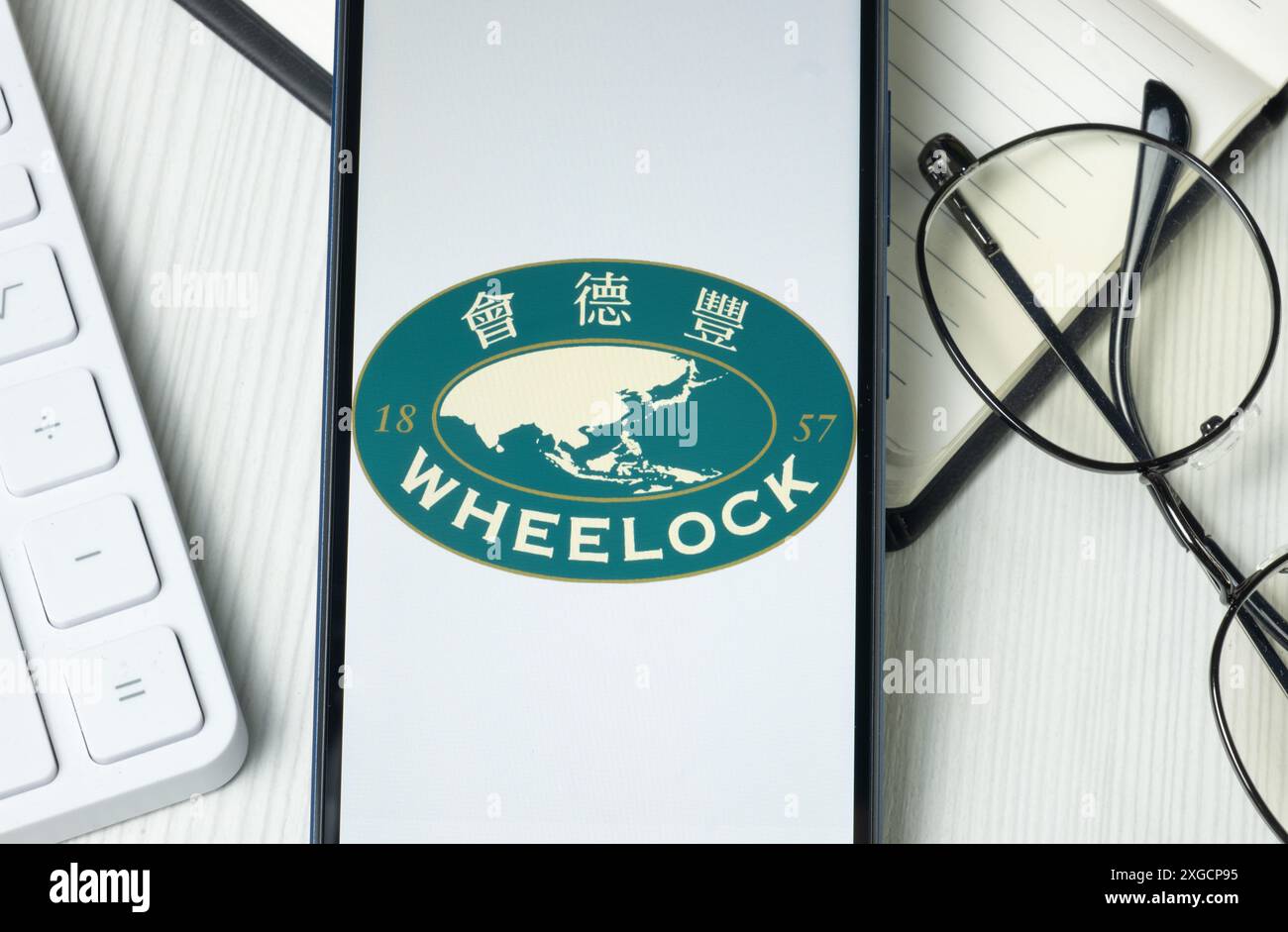 New York, USA - 21 giugno 2024: Wheelock e logo aziendale sullo schermo del telefono, icona dell'azienda. Foto Stock