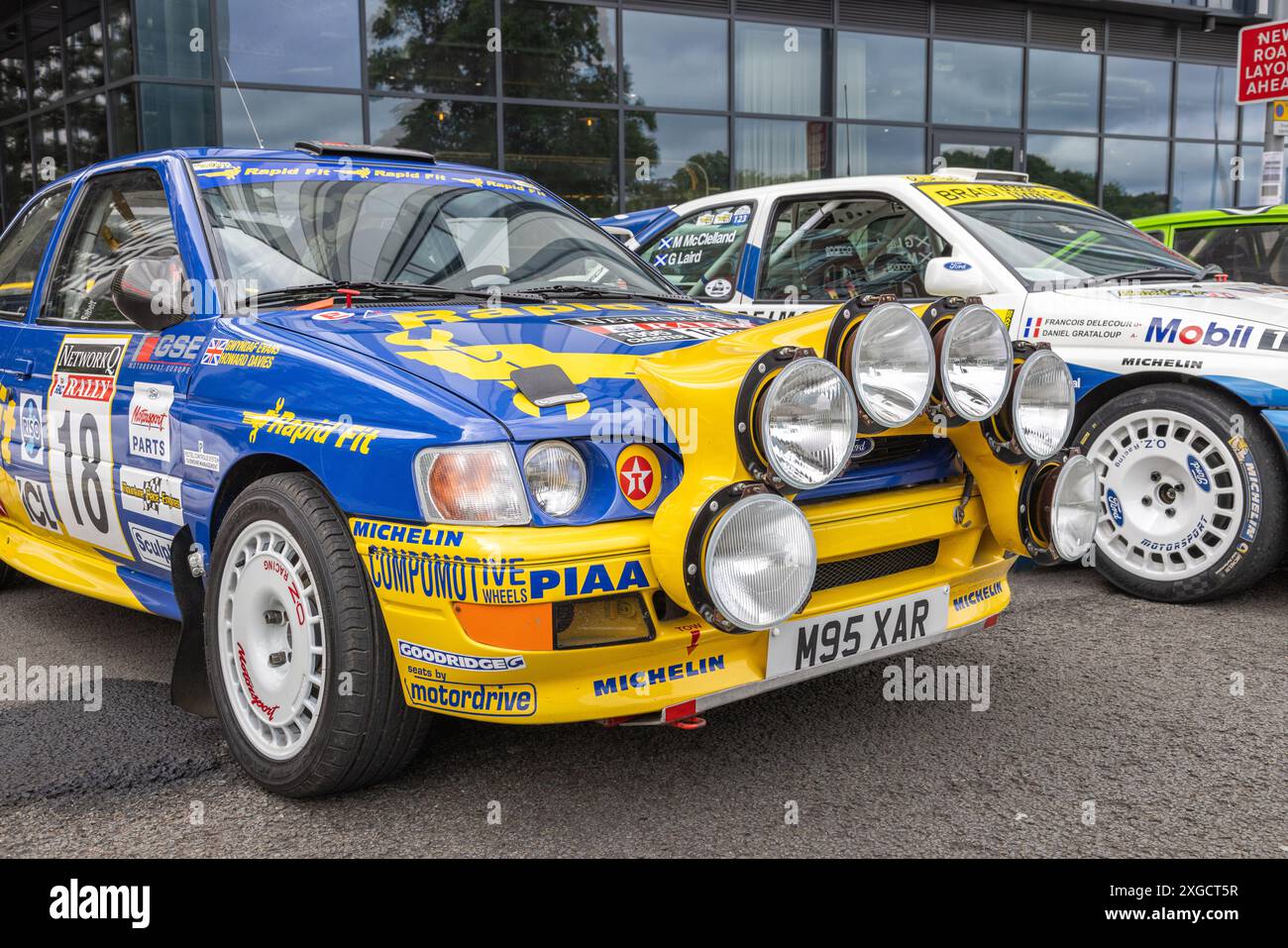 Un paio di auto da rally in piena decalcomania parcheggiate in un ambiente urbano. Foto Stock