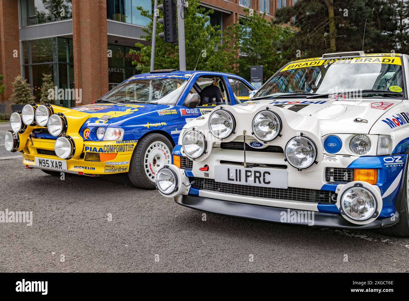 Un paio di auto da rally in piena decalcomania parcheggiate in un ambiente urbano. Foto Stock