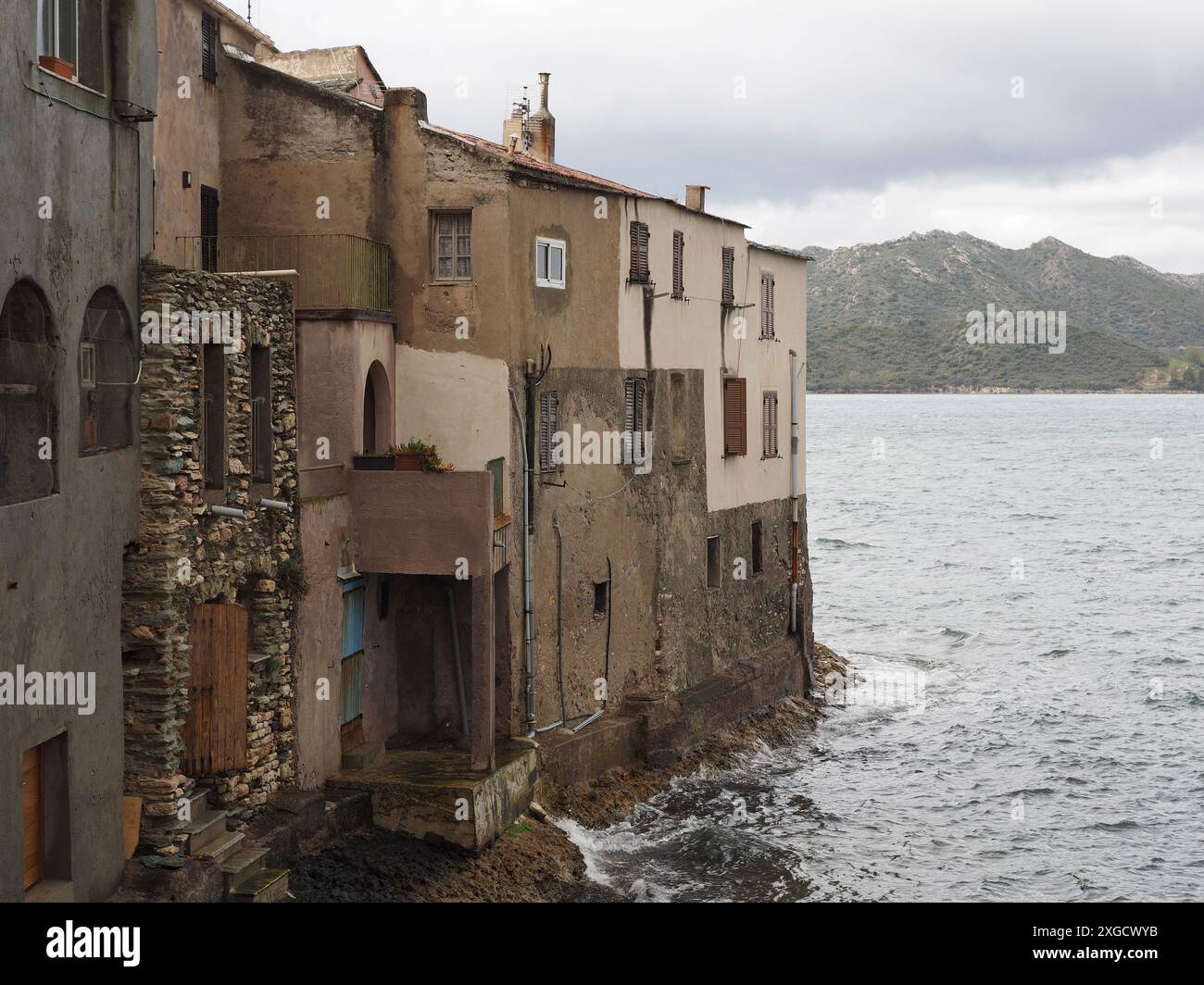 Vecchie case costruite su rocce proprio accanto al mare a Saint Florent, Corsica, Francia Foto Stock