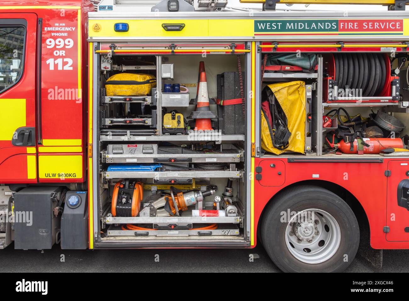 Vista laterale del motopompa antincendio West Midlands. Le porte laterali sono aperte e offrono una visuale dell'attrezzatura di emergenza trasportata sul veicolo. Foto Stock