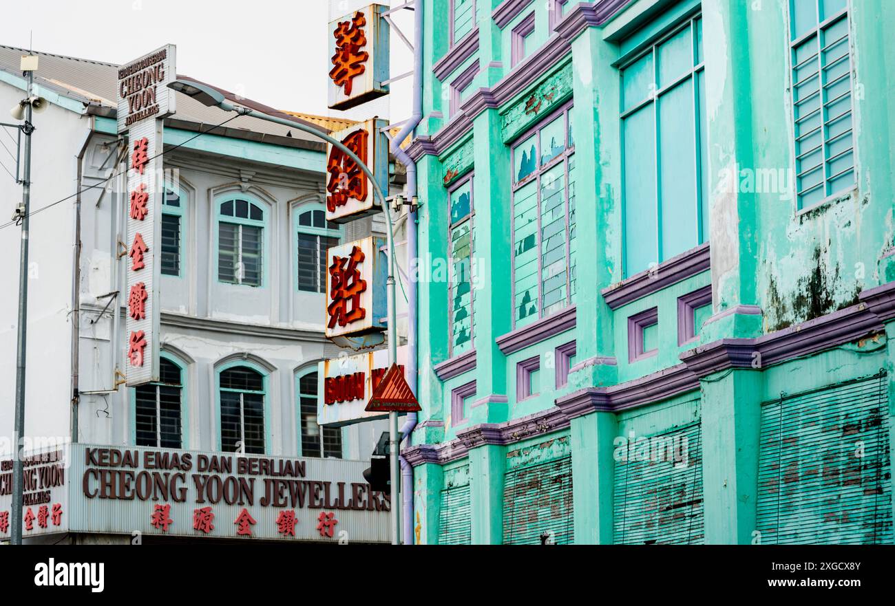 Penang, Malesia-aprile 25 2023: La splendida architettura austera e sbiadita degli edifici di epoca coloniale cinese, ancora attivi, fiancheggiano le strade Foto Stock