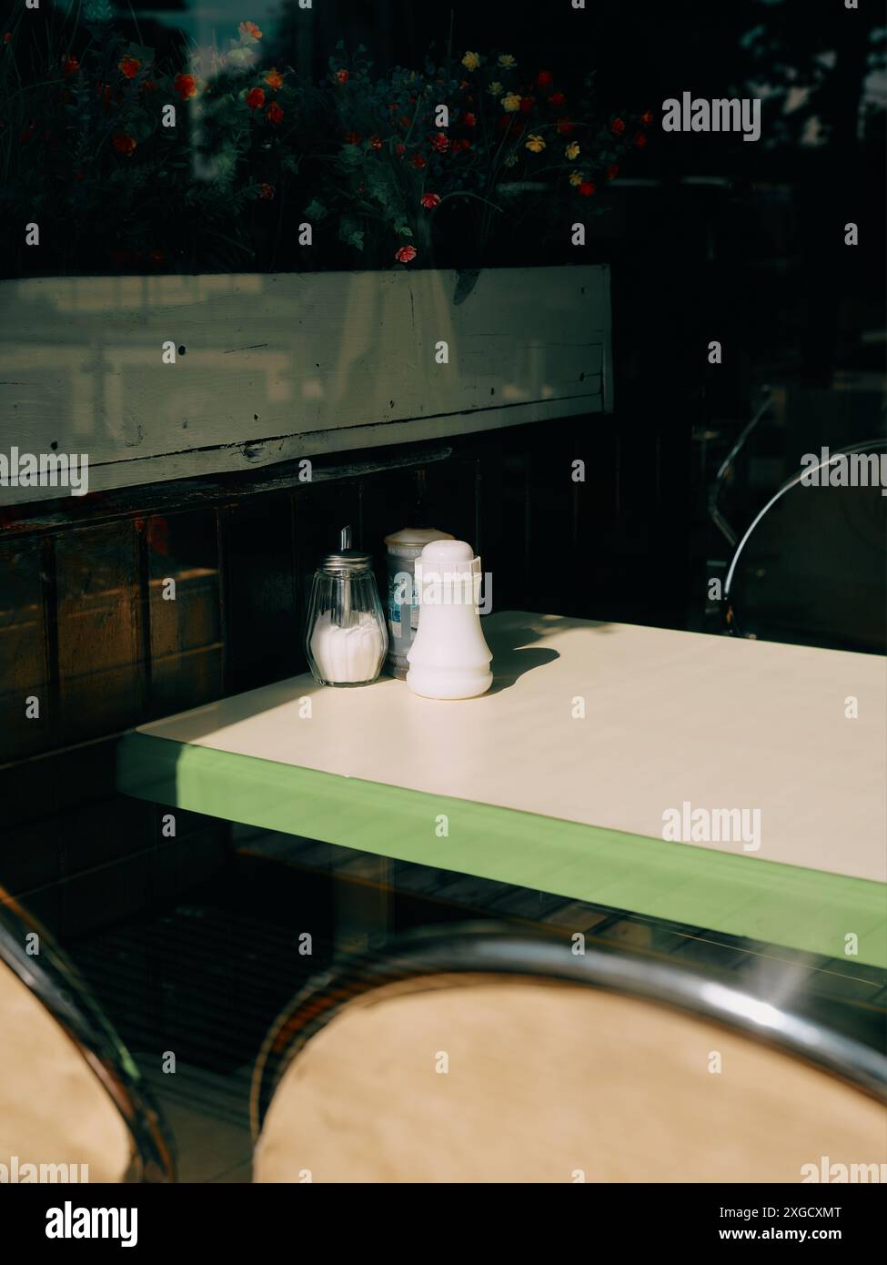 Un tavolo da pranzo/caffetteria vuoto e posti a sedere con condimenti interni - sale e zucchero, tavolo da pranzo con finestra minima Foto Stock