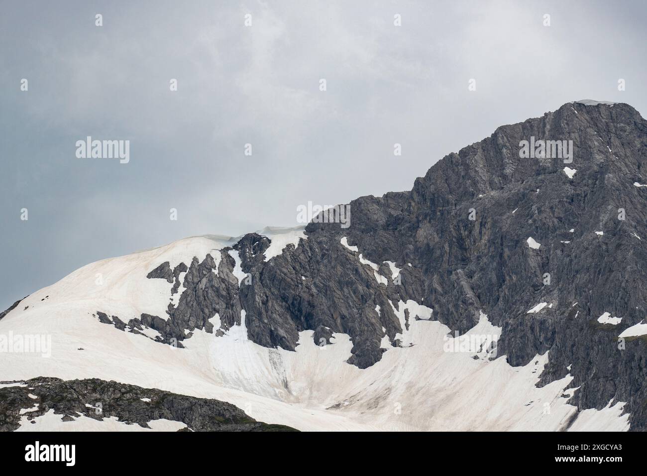 Campo innevato in montagna, cornici, ciaspole in cima, copertura nevosa a strapiombo è un pericolo di valanghe, possibile caduta di neve, freddo di neve Foto Stock
