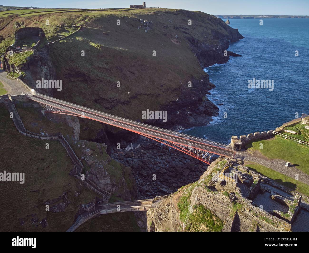 Una vista aerea delle suggestive rovine del castello di Tintagel, che si dice sia il luogo di nascita di re Artù, su un'isola rocciosa al largo della costa, vicino alla città di T. Foto Stock