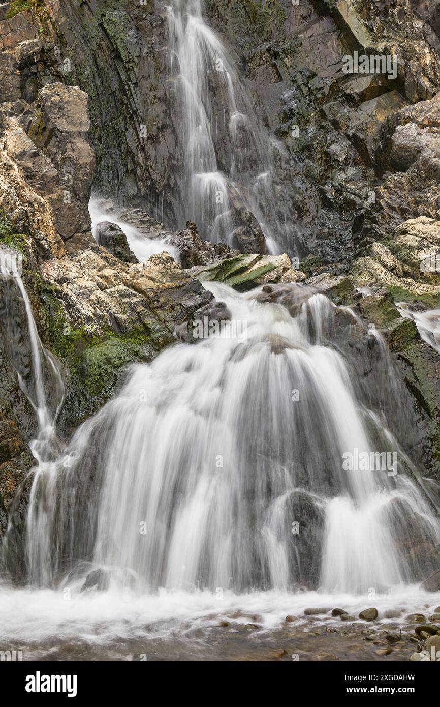 Cascata che si getta lungo una scogliera rocciosa, con movimento sfocato, risultante da una lenta velocità dell'otturatore; a Welcombe Mouth, Hartland, nel nord del Devon, Inghilterra, una Foto Stock