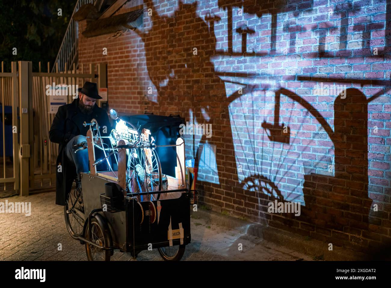Artista con un carro che crea ombre su un muro durante il festival delle luci accese, Eindhoven, Brabante settentrionale, Paesi Bassi, Europa Foto Stock