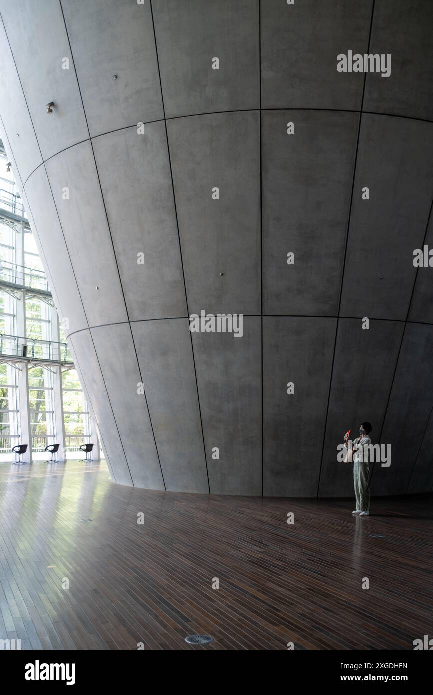 Donne con telefono cellulare che scattano una foto nel foyer del National Art Center di Tokyo in Giappone Foto Stock