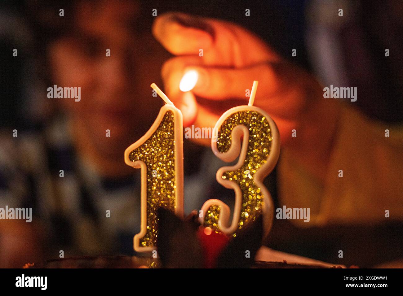 accendere candele con il numero 13 a una festa per adolescenti. Psicologia e sviluppo degli adolescenti Foto Stock