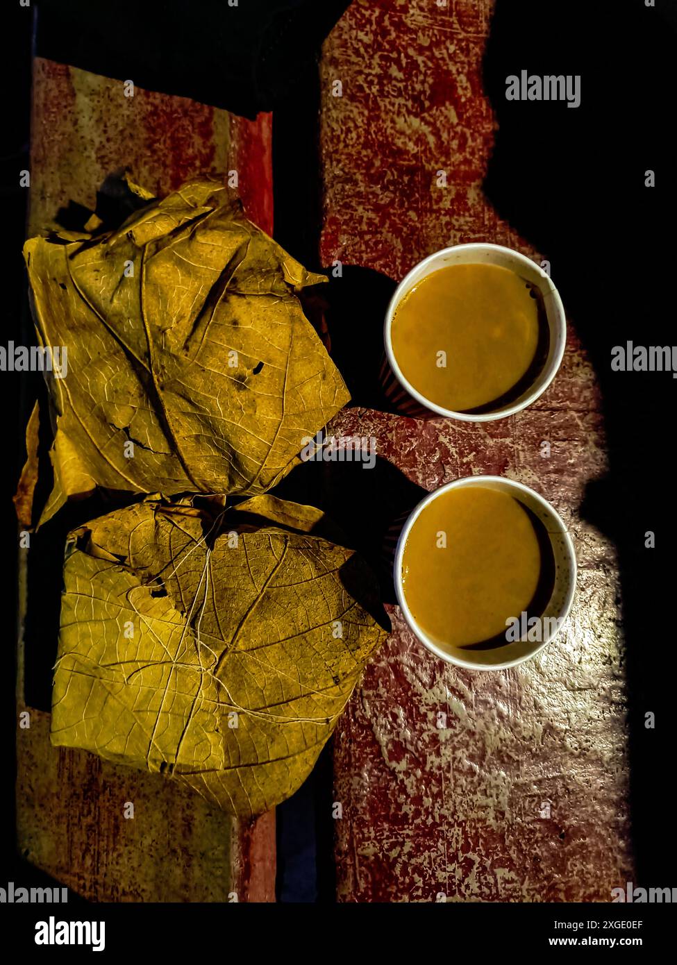 Il tè e il pane tostato confezionato in un sacco di foglie in stile indiano molto tradizionale. In India ci sono ancora alcuni luoghi in cui il cibo è confezionato in foglie. Foto Stock