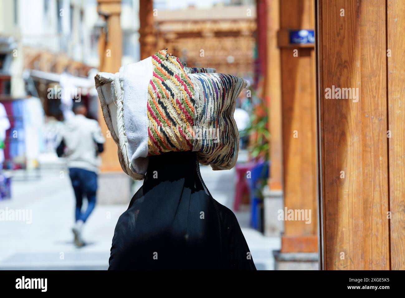 Una donna trasporta merci dal bazar di Assuan, Egitto/ Foto Stock