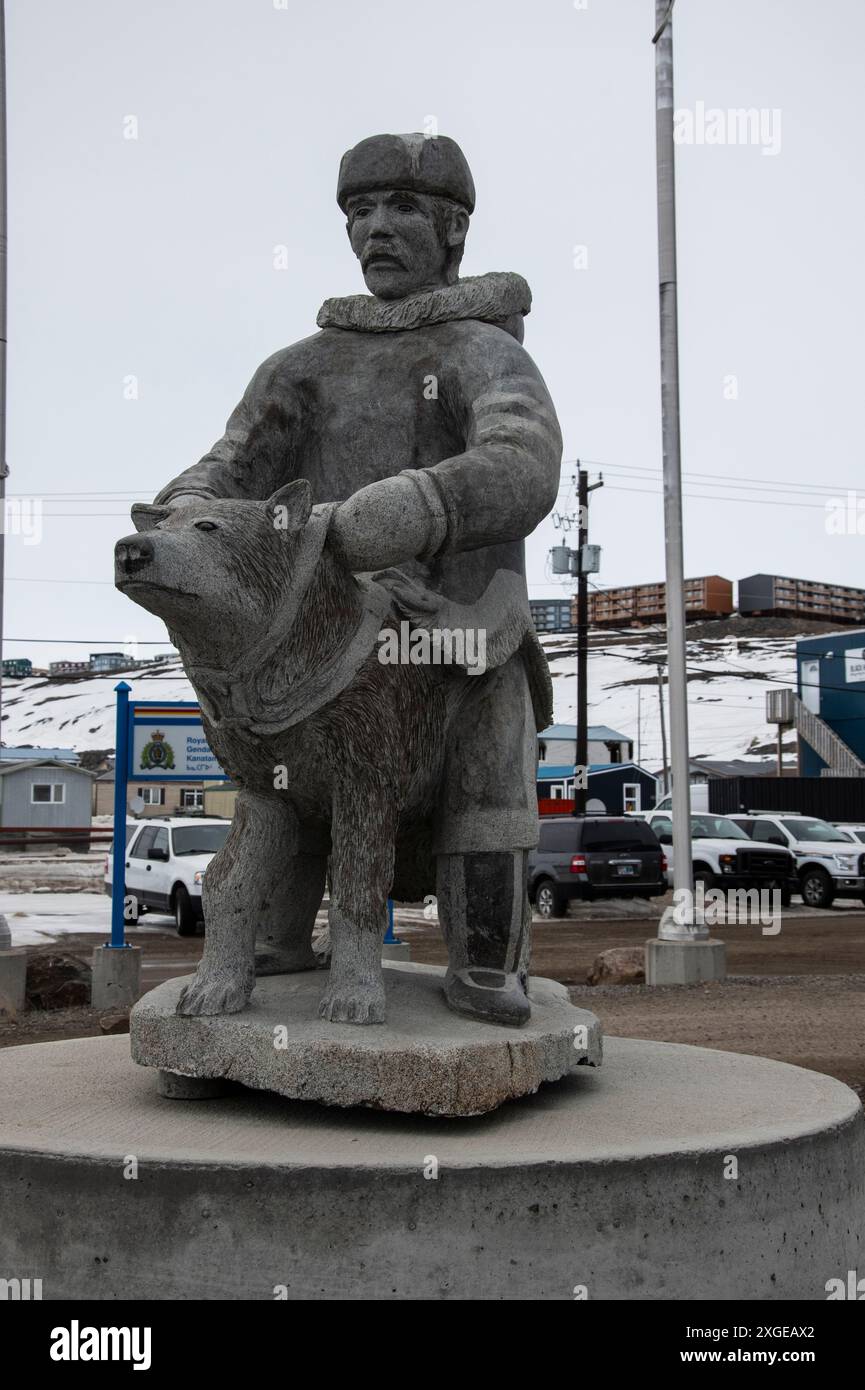 Scultura in pietra di un uomo e un cane Inuit nell'edificio RCMP sulla Federal Road a Iqaluit, Nunavut, Canada Foto Stock