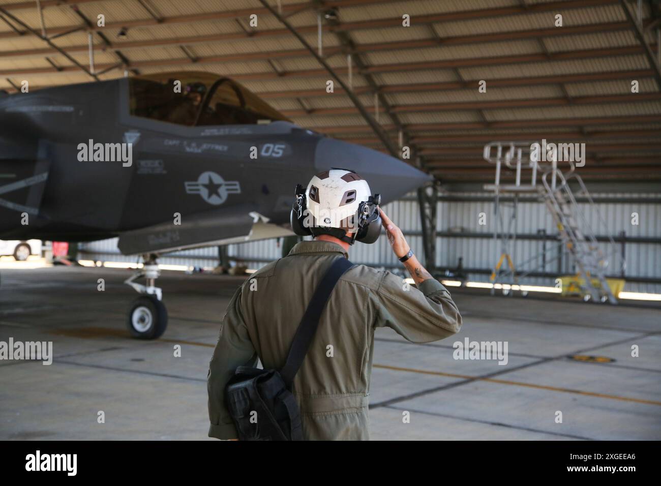 Jarod Volstorf, capitano di un aereo con Marine Fighter Attack Squadron (VMFA) 214, Marine Aircraft Group 13, 3rd Marine Aircraft Wing, saluti capitano Jack Flanagan, un pilota di F-35B Lightning II con VMFA-214, come taxi un F-35B Lightning II armato con una bomba a guida laser della Royal Australian Air Force GBU-12 Paveway II presso la RAAF base Tindal, Northern Territory, Australia, 26 giugno 2024 I marines con VMFA-214 e gli aviatori della RAAF con il No. 75 Squadron caricarono gli ordigni della RAAF sugli F-35B dell'USMC durante l'addestramento bilaterale, mostrando intercambiabilità tra RAAF e U.S. Mari Foto Stock