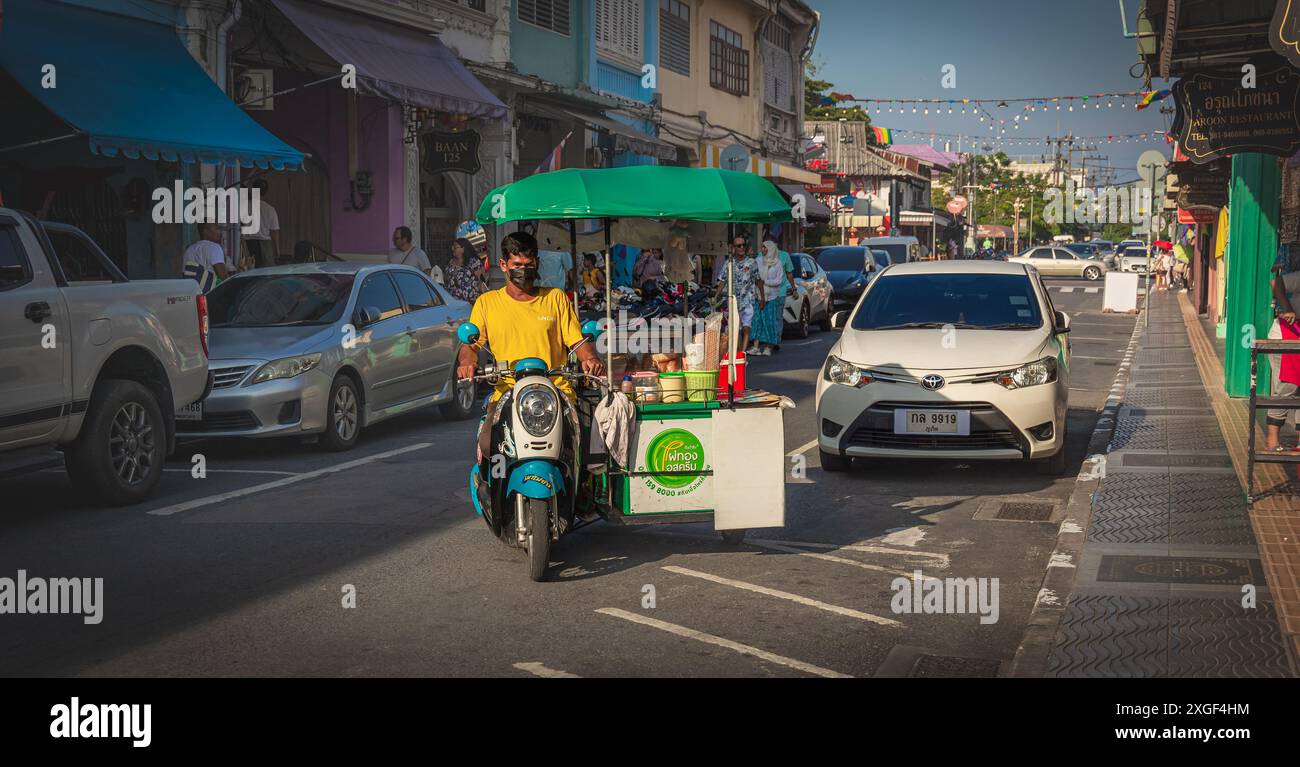 Bancarelle di cibo di strada mobile nella città vecchia di Phuket. Fornitore di cibo in moto in Thailandia. Fornitore di cibo che guida la sua moto per vendere fast food. Foto Stock