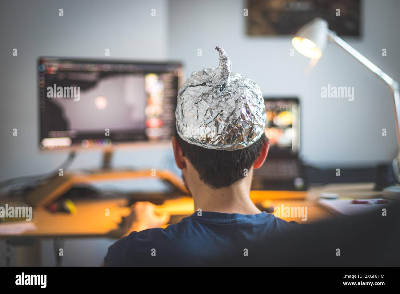 Il giovane indossa un cappuccio in alluminio, un concetto di teoria della cospirazione Foto Stock