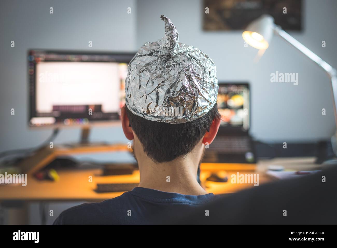 Il giovane indossa un cappuccio in alluminio, un concetto di teoria della cospirazione Foto Stock