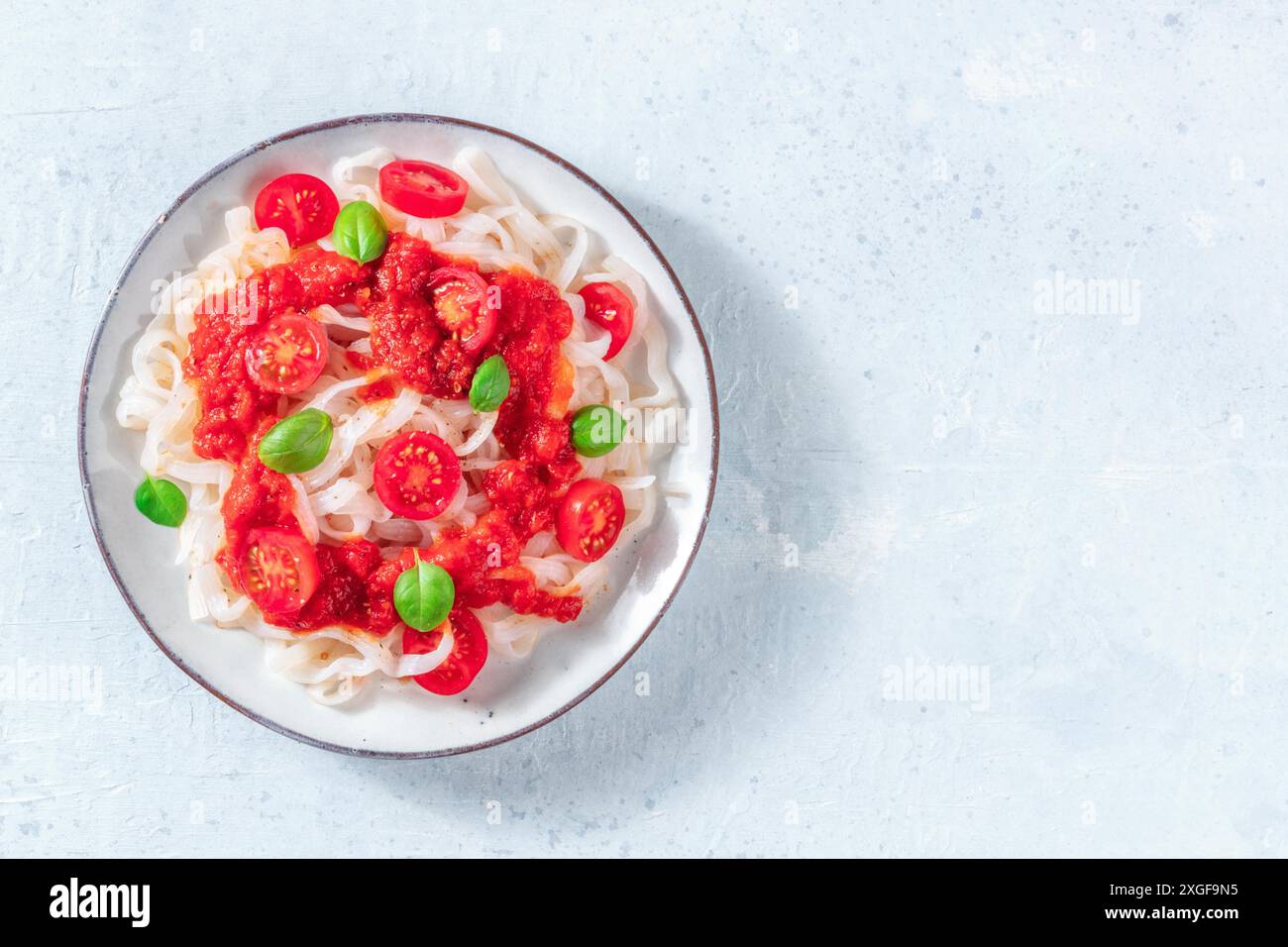 Pasta konjac con pomodori, pasto vegano a basso contenuto calorico, sparato dall'alto con un posto per il testo Foto Stock