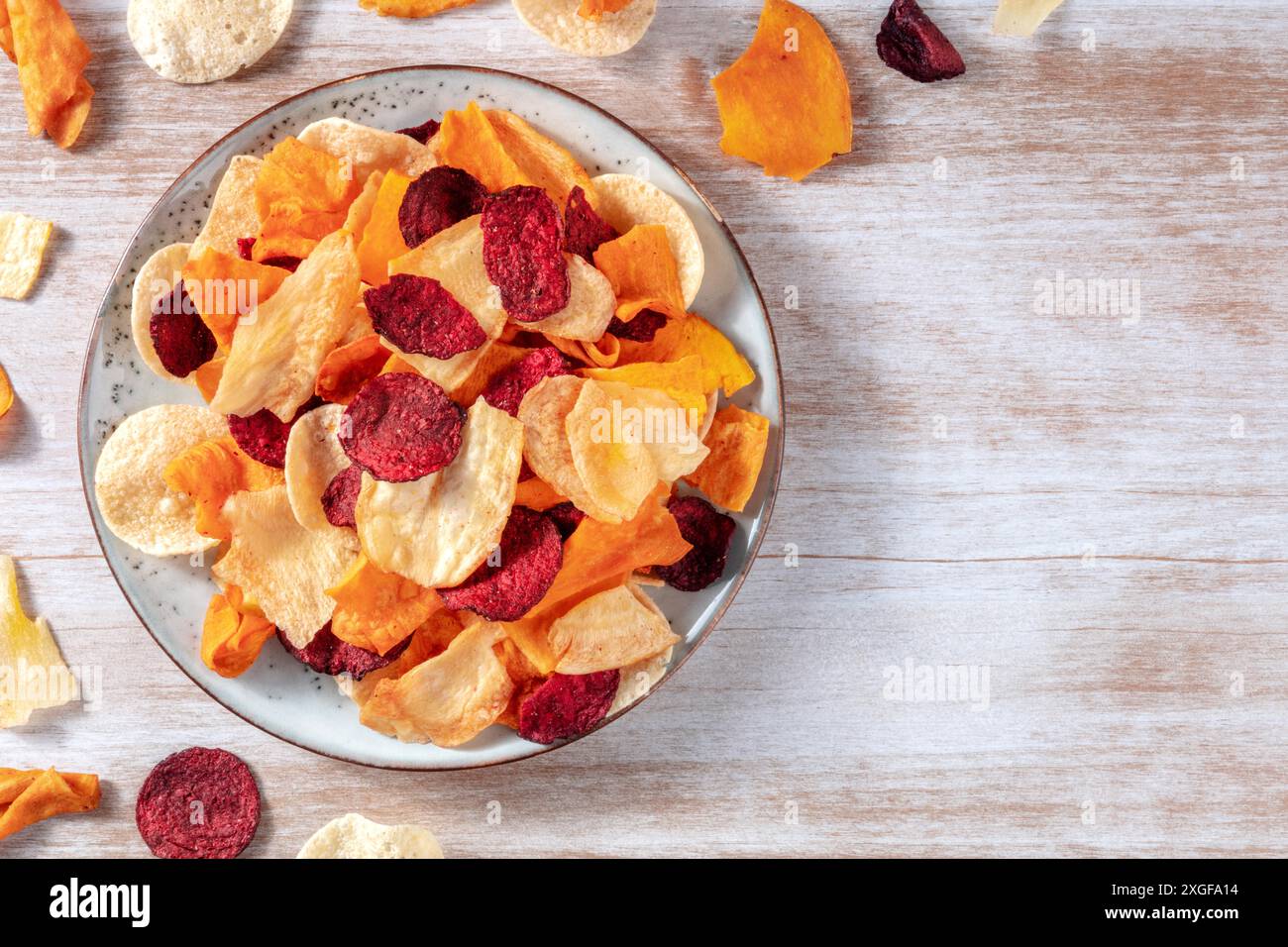 Patatine vegetali, colpo sopra un piatto, uno spuntino vegano sano con un posto per il testo Foto Stock