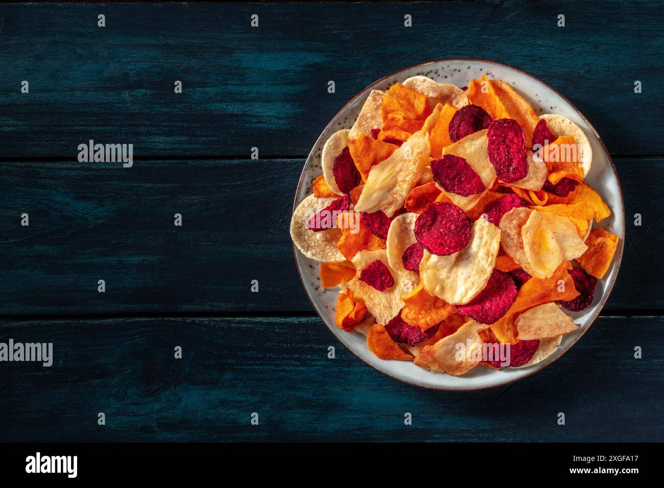 Trucioli di verdure, scattati dall'alto su uno sfondo di legno scuro con un posto per il testo Foto Stock