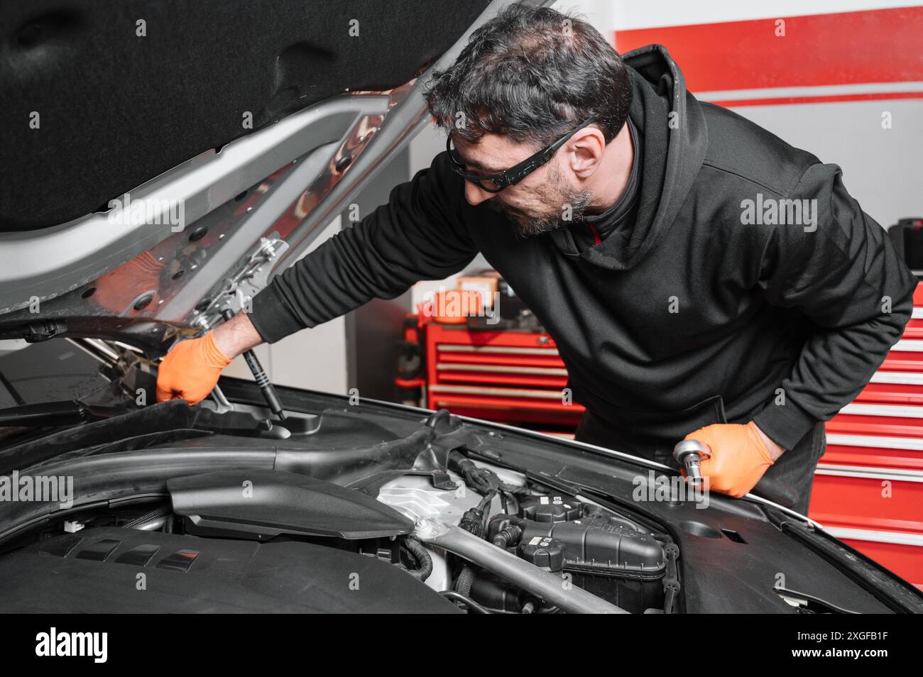 Meccanico automatico che lavora e ripara su motore di automobile in garage di meccanica. Servizio auto. Foto di alta qualità Foto Stock