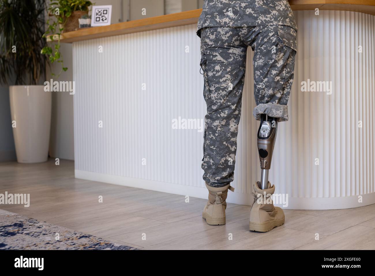 Soldato militare con gamba protesica in piedi al bancone in clinica protesica, copia spazio Foto Stock