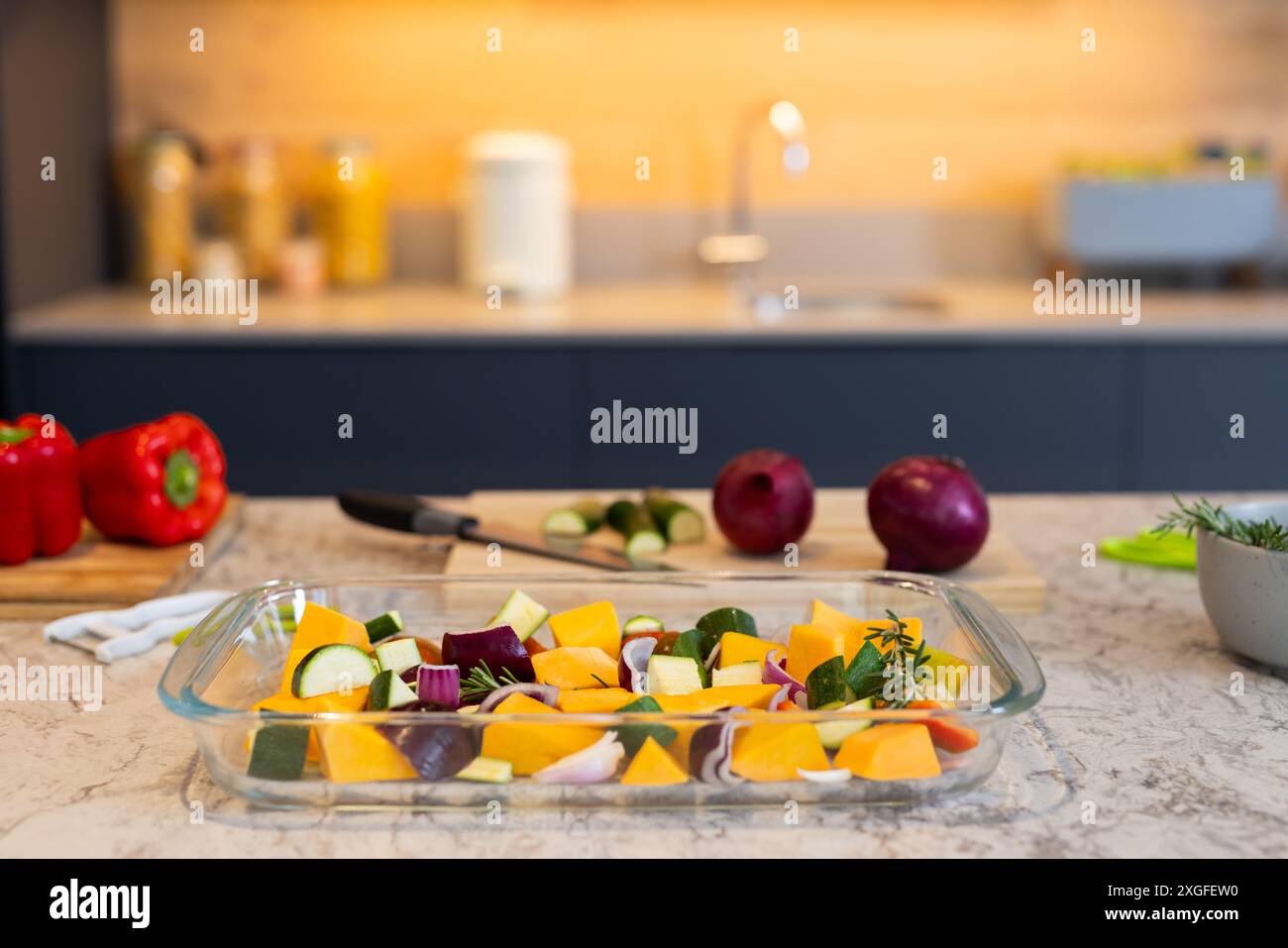 Preparazione di verdure in cucina, piatto di vetro con verdure tritate sul piano di lavoro, copia spazio Foto Stock