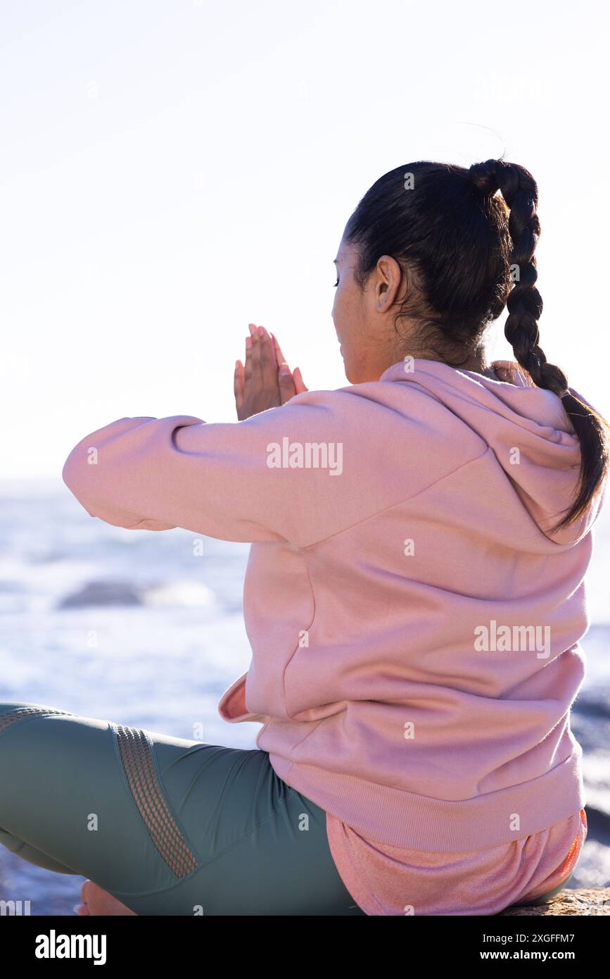 Meditazione sull'oceano, donna matura che pratica yoga e tecniche di rilassamento Foto Stock