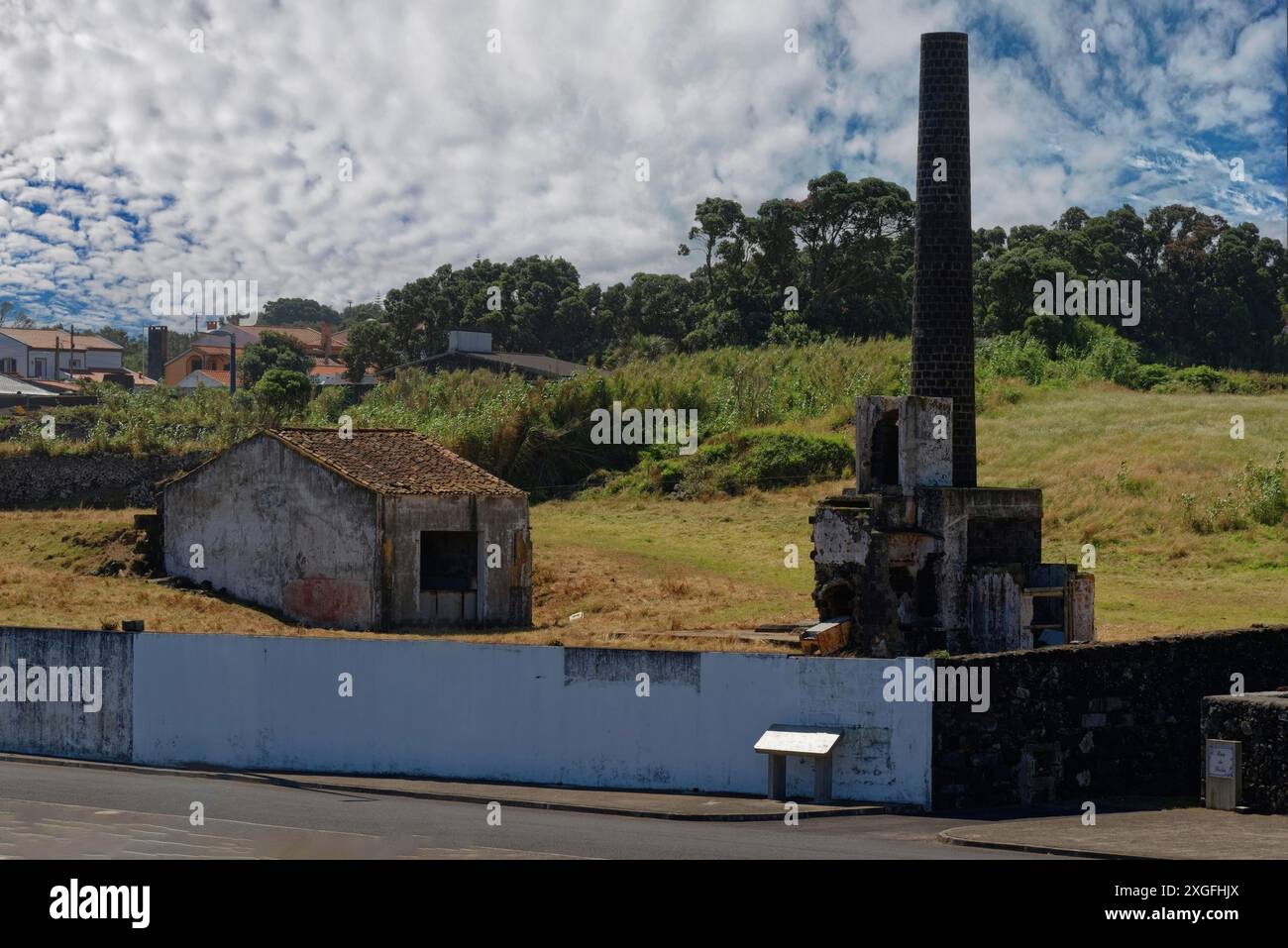 Vecchia fabbrica di cattura delle balene con un camino alto in piedi in un campo sotto un cielo parzialmente nuvoloso, Capelas, isola di Sao Miguel, Azzorre, Portogallo Foto Stock