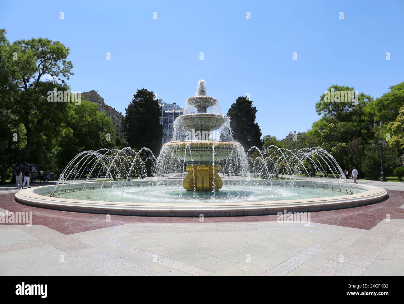 BAKU, AZERBAIGIAN - 28 GIUGNO 2024: Persone non identificate che camminano accanto alla splendida fontana del Parco locale in una calda giornata estiva Foto Stock
