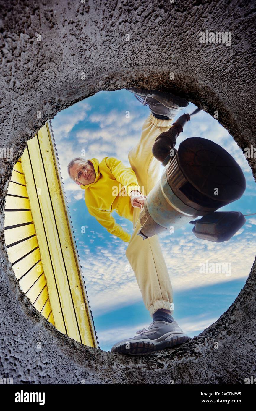 Prima di pulire il serbatoio settico, il proprietario di casa inonda la pompa fognaria per pompare le acque reflue. Foto Stock