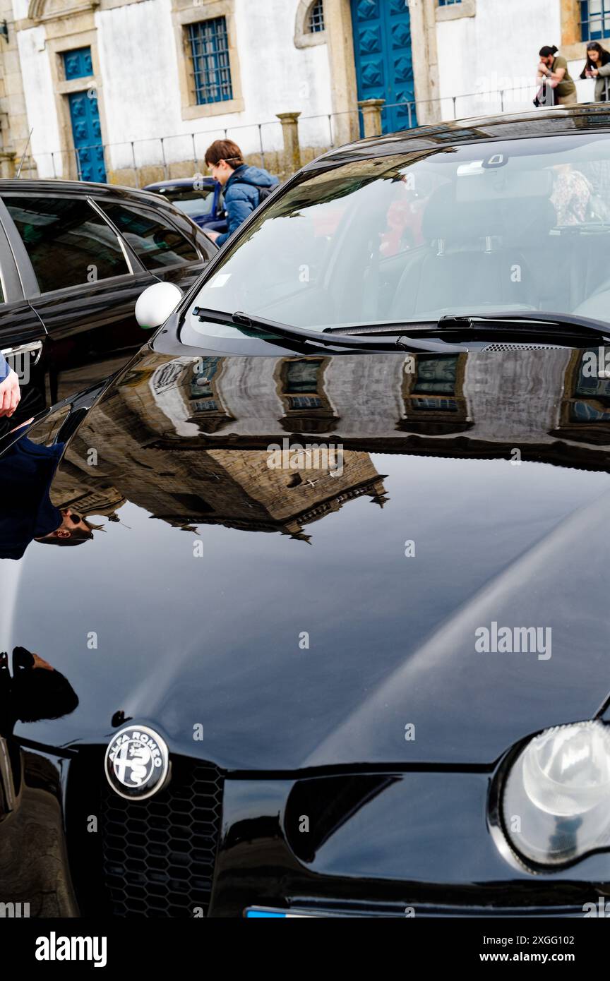 La Cattedrale di Porto si rifletteva sul cofano di un'Alfa Romeo durante un incontro con un'auto, unendo l'architettura storica con l'elegante design automobilistico Foto Stock