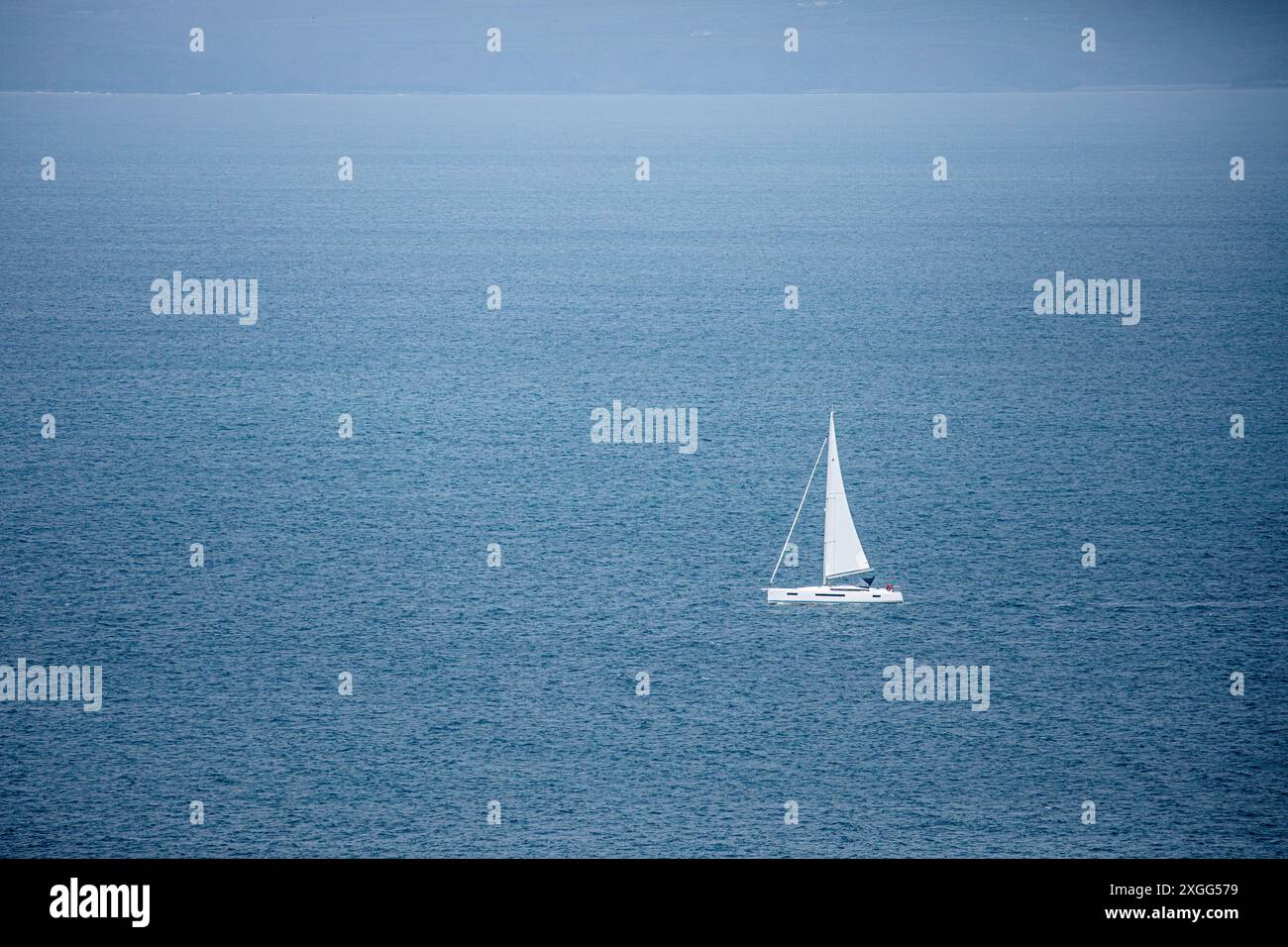 Barca a vela/yacht solitari su un mare blu calmo Foto Stock