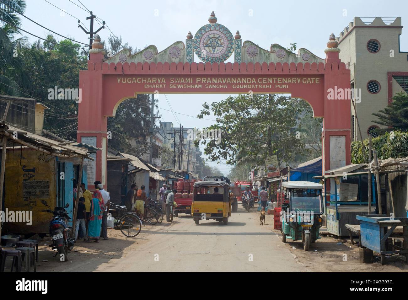 Un'arcata commemorativa per il quartiere del mercato dietro le quinte con gli acquirenti e il traffico locale, Puri, il più antico dei quattro centri religiosi indù più sacri dell'India Foto Stock