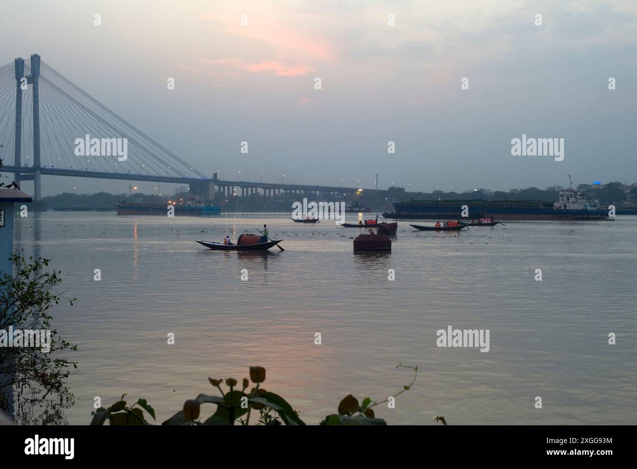 Gondole che regnano lungo il fiume Hooghly verso il ponte Vidyasagar Setu al tramonto, Kolkata (Calcutta), Bengala Occidentale, India, Asia Foto Stock