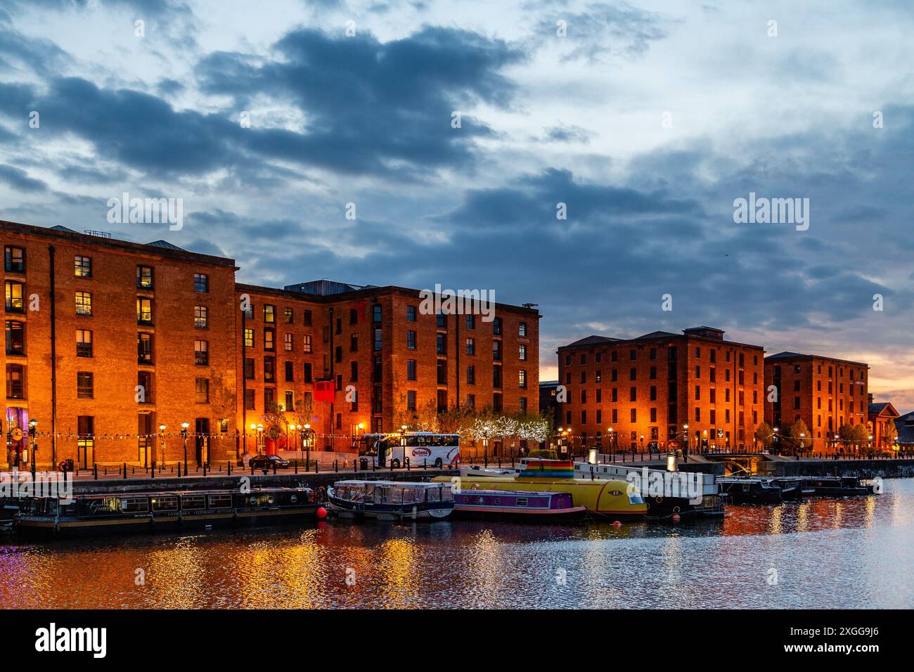 Vista al crepuscolo degli storici magazzini in mattoni illuminati al Royal Albert Dock e del lungomare di Liverpool al crepuscolo, Merseyside, Inghilterra Foto Stock