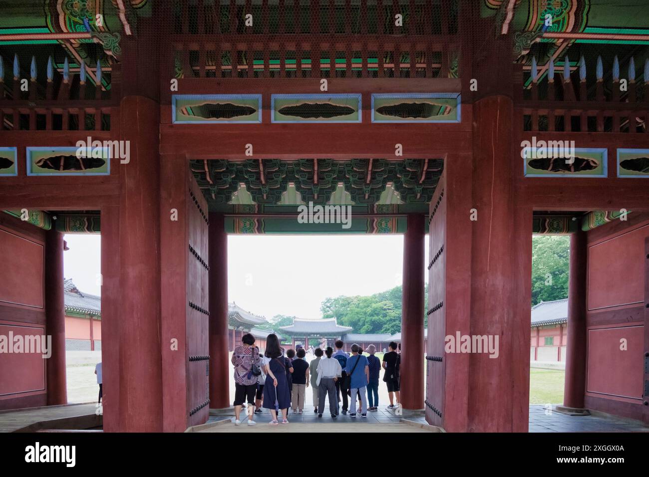 Porta ornata di un tradizionale palazzo coreano, con i turisti che esplorano il sito storico Foto Stock