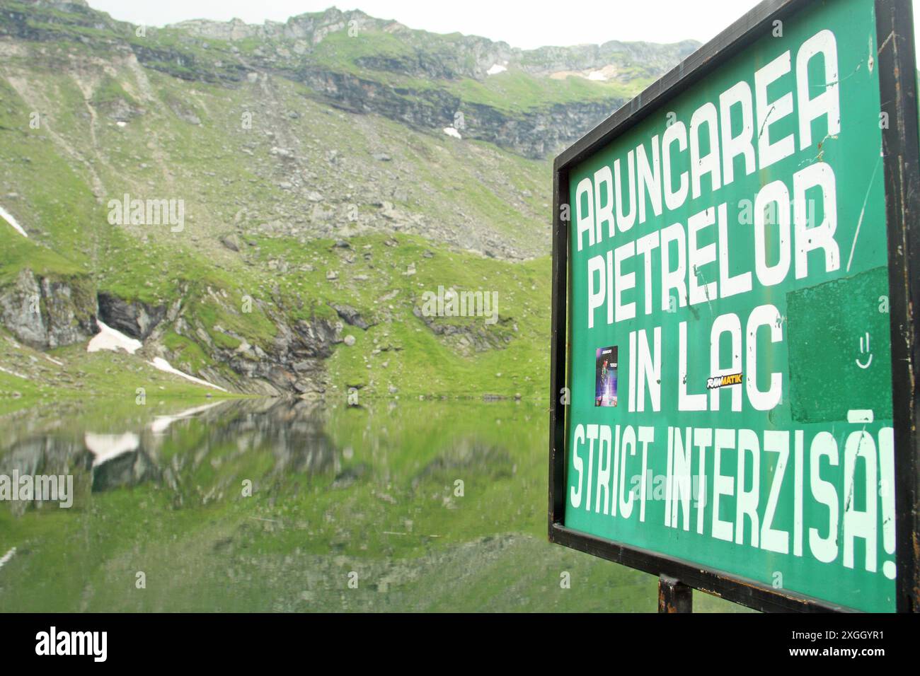 Cartello di avvertimento "gettare pietre nel lago è severamente vietato" presso il lago Balea, vicino alla strada Transfagarasan, Transilvania, contea di Sibiu, Romania Foto Stock