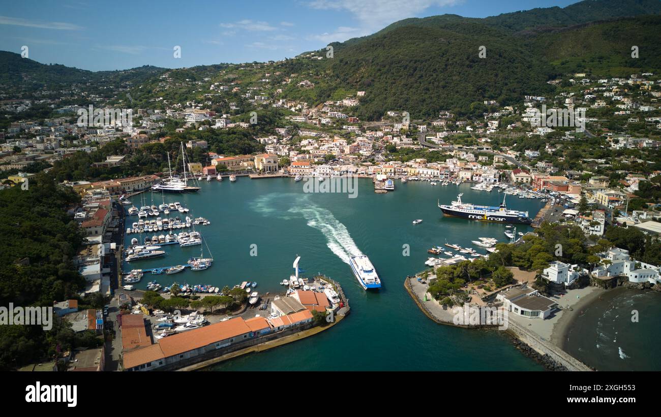 Il Porto di Ischia è un vivace centro marittimo situato sull'isola di Ischia, in Italia, rinomato per il suo paesaggio costiero panoramico e per il suo significato storico Foto Stock