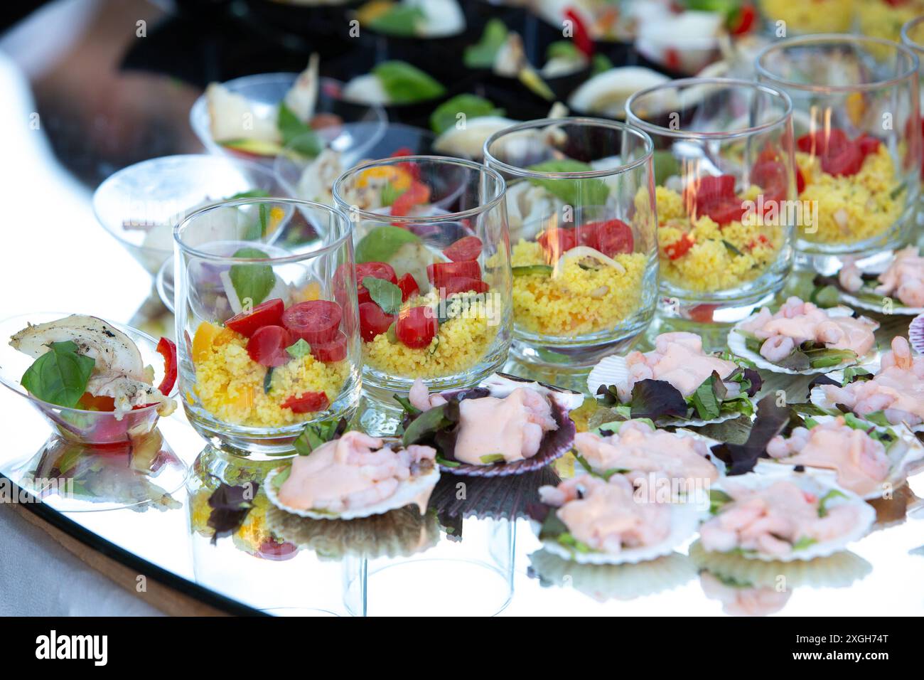 Varietà di colorati antipasti nuziali esposti su un tavolo di vetro, perfetti per un ricevimento di nozze Foto Stock
