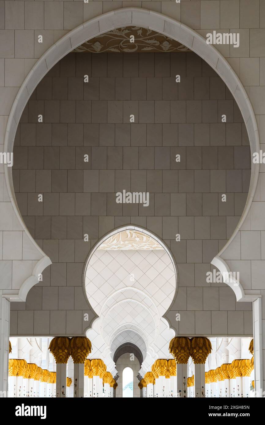 Abu Dhabi, Emirati Arabi Uniti - 4 gennaio 2024: Una tranquilla passeggiata attraverso l'enfilade della Moschea dello sceicco Zayed. Foto Stock