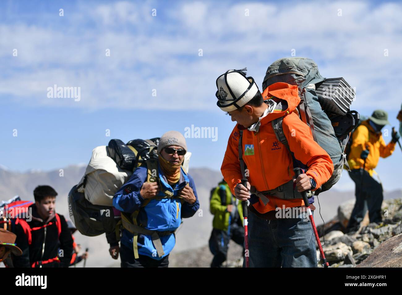 (240709) -- AKTO, 9 luglio 2024 (Xinhua) -- salendo la montagna, Taxibayi Janibaiki (fronte) si gira per osservare i suoi compagni dietro di lui nella regione autonoma Xinjiang Uygur del nord-ovest della Cina, 4 luglio 2024. Il Muztagh Ata, situato sull'altopiano di Pamir a un'altitudine di oltre 7.500 metri nella regione autonoma di Xinjiang Uygur, nella Cina nord-occidentale, è un'attrazione per gli appassionati di alpinismo provenienti da tutto il mondo. Durante la stagione delle arrampicate, la gente si riunisce nel villaggio di Subax, nella contea di Akto, ai piedi del Muztagh Ata per l'alpinismo. Per quanto riguarda la gente del posto che ha familiarità con il Foto Stock