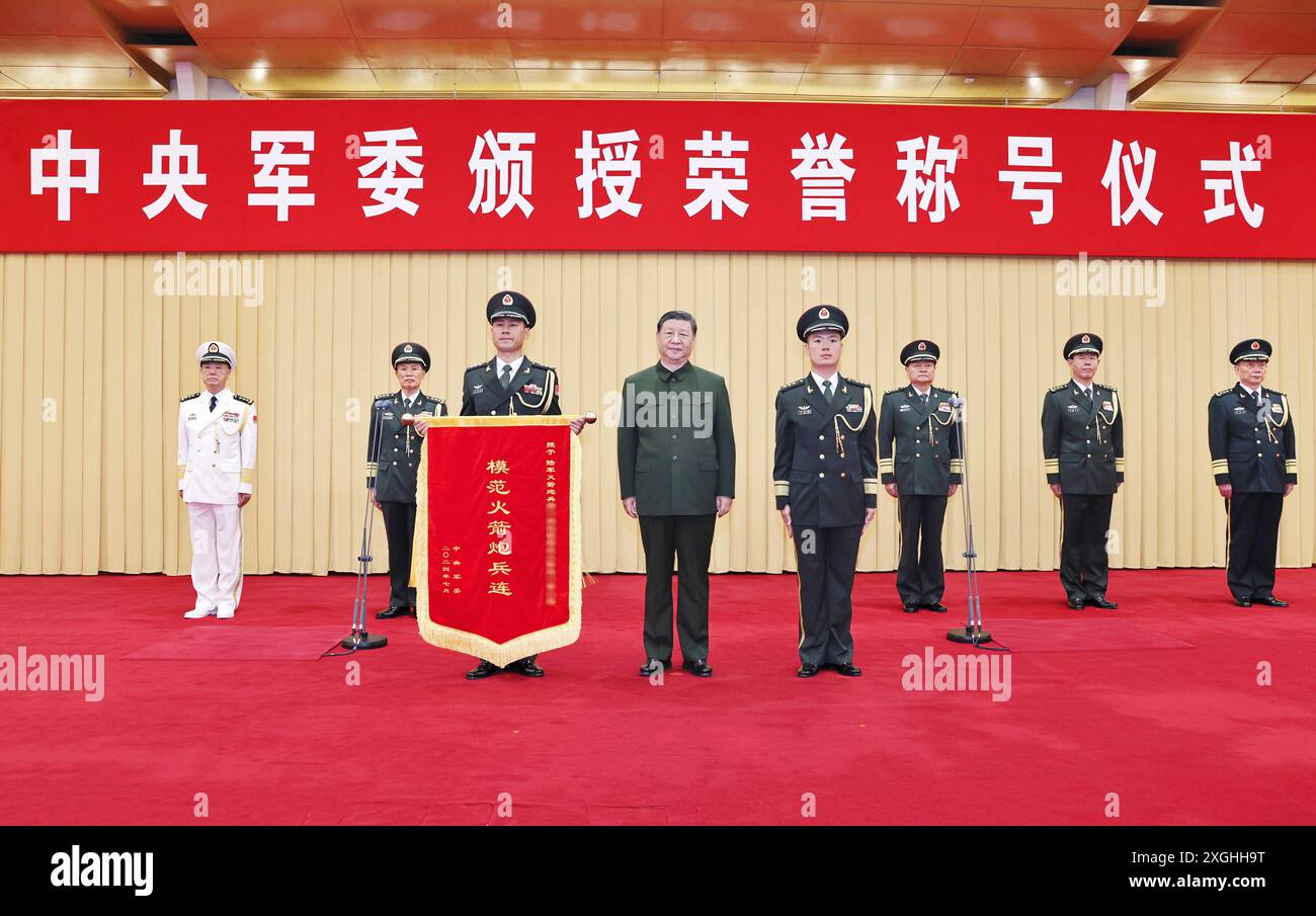 Pechino, Cina. 9 luglio 2024. Il presidente cinese Xi Jinping, anche segretario generale del Comitato centrale del Partito Comunista Cinese e presidente della Commissione militare centrale (CMC), conferisce una bandiera d'onore a una compagnia militare dell'Esercito Popolare di Liberazione Cinese, a cui è stato conferito il titolo onorario di "Model Rocket Artillery Company", e posa per le foto con i rappresentanti dell'unità premiata durante una cerimonia tenuta dal CMC a Pechino, capitale della Cina, il 9 luglio 2024. Crediti: Li Gang/Xinhua/Alamy Live News Foto Stock