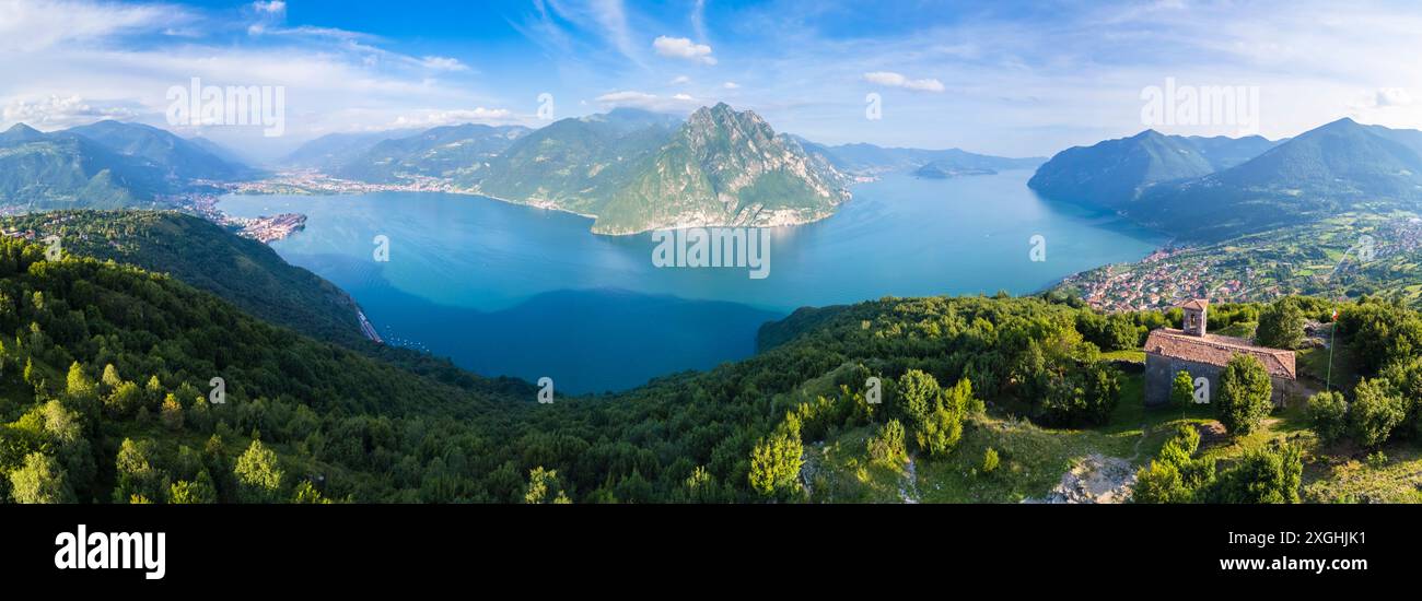 Vista aerea della piccola chiesa di San Defendente che domina il lago d'Iseo in estate. Solto Collina, Lago d'Iseo, Bergamo, Lombardia, Italia. Foto Stock