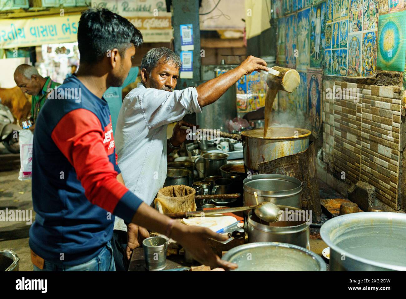 Ahmenabad, India - 20 ottobre 2023: Un venditore di chai di strada viene visto vendere chai di notte. Vecchio indiano che fa un lavoro informale, concetto di sostentamento in Foto Stock